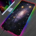 Mousepad extragrande con estampado de nebulosa y borde iluminado RGB sobre un escritorio